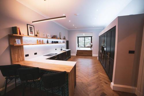 A Modern Black and White Kitchen with a black cabinetry in beaded carbon and a white kitchen worktops.