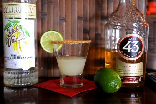 bottle of stoli vanilla and licor 43 and a key lime pie shot with graham cracker crust rim and fresh lime garnish