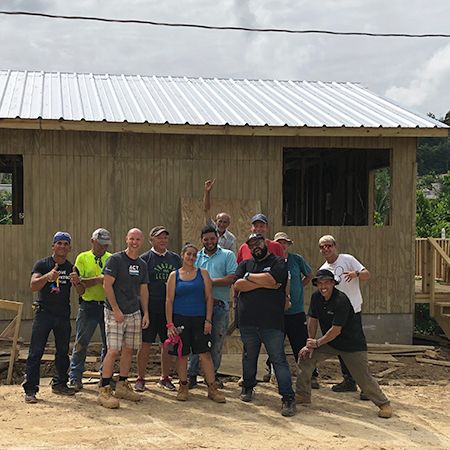 team in front of new house